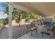 Covered patio and spacious backyard with gravel and mature trees at 17713 N Larkspur Ln, Surprise, AZ 85374