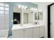 Bathroom features double sinks, large mirror, and a glass-block window at 17713 N Larkspur Ln, Surprise, AZ 85374