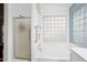 Bathroom with shower and bathtub, and a glass block window for natural light at 17713 N Larkspur Ln, Surprise, AZ 85374