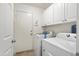 Laundry room with washer, dryer, and built-in cabinets at 17713 N Larkspur Ln, Surprise, AZ 85374