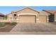 Tan two-car garage home with landscaped yard at 18265 N 116Th Dr, Surprise, AZ 85378