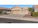 Tan two-car garage home with desert landscaping at 18265 N 116Th Dr, Surprise, AZ 85378