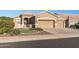 Tan two-car garage home with desert landscaping at 18265 N 116Th Dr, Surprise, AZ 85378