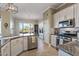 Bright kitchen with white cabinets, granite counters, and view to backyard at 18265 N 116Th Dr, Surprise, AZ 85378