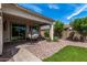 Landscaped backyard with covered patio, hanging chair and fire pit at 19919 W Lincoln St, Buckeye, AZ 85326