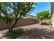 Backyard with gravel landscaping, mature trees and a wall at 19919 W Lincoln St, Buckeye, AZ 85326