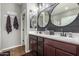 Elegant bathroom with dual sinks, large mirrors, and dark brown vanity at 19919 W Lincoln St, Buckeye, AZ 85326