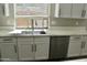 White kitchen cabinets, sink, and dishwasher with quartz countertop at 23306 N 40Th Pl, Phoenix, AZ 85050