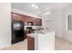 Kitchen with wood cabinets, black appliances, and island at 3330 S Gilbert Rd # 2001, Chandler, AZ 85286