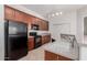 Modern kitchen features dark wood cabinets, black appliances, and a double sink at 3330 S Gilbert Rd # 2001, Chandler, AZ 85286