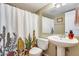 Clean bathroom with pedestal sink, shower/tub combo, and patterned shower curtain at 3343 E Anderson Dr, Phoenix, AZ 85032