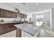 Kitchen with island, dark cabinets, and granite countertops at 36085 W Prado St, Maricopa, AZ 85138