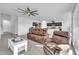 Living room with brown leather sectional and recliner, white coffee table, and ceiling fan at 36085 W Prado St, Maricopa, AZ 85138