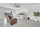 Living room with brown leather furniture, a ceiling fan, and sliding glass doors at 36085 W Prado St, Maricopa, AZ 85138