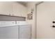 Laundry room with washer, dryer, and overhead cabinets at 3832 N 162Nd Ln, Goodyear, AZ 85395