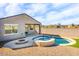 Charming backyard with a fire pit and kidney-shaped pool at 40634 W Hillman Dr, Maricopa, AZ 85138