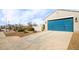 Two-car garage with teal doors and ample driveway space at 40634 W Hillman Dr, Maricopa, AZ 85138