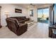 Relaxing living room with leather sectional and sliding glass door to backyard at 40634 W Hillman Dr, Maricopa, AZ 85138