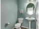 Clean and updated powder room with pedestal sink and oval mirror at 4124 E Toledo St, Gilbert, AZ 85295