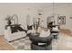 Bright living room with white sofa and black armchairs, hardwood floors, and a view into the dining area at 5101 N Casa Blanca Dr # 301, Paradise Valley, AZ 85253