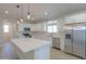 Modern kitchen with white cabinets, island, and stainless steel appliances at 57968 W Fulcar Rd, Maricopa, AZ 85139