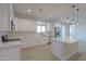 Modern kitchen with white cabinets, island, and stainless steel appliances at 57968 W Fulcar Rd, Maricopa, AZ 85139