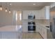 Modern kitchen with white cabinets and stainless steel appliances at 57968 W Fulcar Rd, Maricopa, AZ 85139