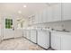 Bright laundry room, featuring white cabinets, updated washer and dryer, and a convenient sink at 5801 E Exeter Blvd, Phoenix, AZ 85018