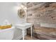 Stylish powder room with a pedestal sink, wood-paneled accent wall, and elegant mirror at 5801 E Exeter Blvd, Phoenix, AZ 85018