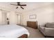 Bright bedroom with ceiling fan, dresser, and comfortable armchair at 653 N Abalone Dr, Gilbert, AZ 85233