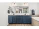 Double vanity bathroom with navy cabinets and a large mirror at 6551 N 127Th Dr, Glendale, AZ 85307