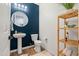 Stylish powder room with pedestal sink and wood shelving at 6551 N 127Th Dr, Glendale, AZ 85307