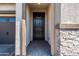 Inviting entryway with dark wood door and stone accent wall at 6551 N 127Th Dr, Glendale, AZ 85307