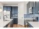 Modern kitchen with white quartz countertops, blue cabinetry, and stainless steel appliances at 6551 N 127Th Dr, Glendale, AZ 85307