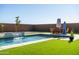 Inviting pool area with a water feature, lush grass, and patio furniture at 6551 N 127Th Dr, Glendale, AZ 85307