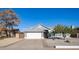 Single-story home with gray exterior, white garage door, and landscaped yard at 7710 W Aster Dr, Peoria, AZ 85381