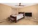 Relaxing bedroom with a simple bed, TV and bench at 7844 W Bonitos Dr, Phoenix, AZ 85035