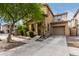 Tan two-story house with a tree in front at 7844 W Bonitos Dr, Phoenix, AZ 85035