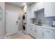 Modern laundry room with stacked washer and dryer, and white cabinets at 7878 E Gainey Ranch Rd # 3, Scottsdale, AZ 85258