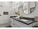 Double vanity bathroom with dark countertops and modern fixtures at 8025 E Redwing Rd, Scottsdale, AZ 85250