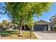 Tan house with dark garage door, mature tree, and landscaped yard at 8707 N 3Rd Ave, Phoenix, AZ 85021