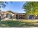 Tan house with dark garage door, covered patio, and landscaped yard at 8707 N 3Rd Ave, Phoenix, AZ 85021