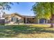 Tan house with dark garage door, covered patio, and landscaped yard at 8707 N 3Rd Ave, Phoenix, AZ 85021