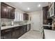 Modern kitchen with white countertops, dark wood cabinets, and tile flooring at 9714 W Rodeo Ct, Sun City, AZ 85373