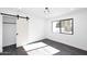 Bedroom with barn door, window and dark gray wood-look floors at 9789 E Cinnabar Ave, Scottsdale, AZ 85258