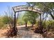 Community entrance with a metal arch and desert landscape at 9789 E Cinnabar Ave, Scottsdale, AZ 85258