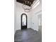 Bright entryway with a large chandelier and elegant iron front door at 9789 E Cinnabar Ave, Scottsdale, AZ 85258