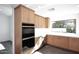 Modern kitchen with light wood cabinets, quartz countertops, and double oven at 9789 E Cinnabar Ave, Scottsdale, AZ 85258