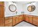 Double vanity bathroom with light wood cabinets and quartz countertops at 10009 E Michigan Ave, Sun Lakes, AZ 85248