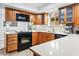 Modern kitchen features wood cabinets, black appliances, and ample counter space at 10009 E Michigan Ave, Sun Lakes, AZ 85248